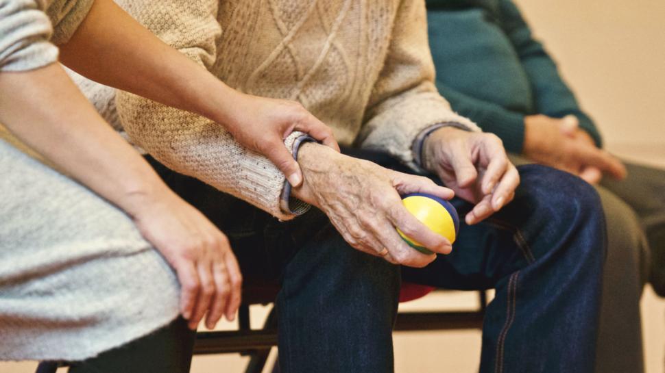 Free Image of Close-up of elderly hands holding a ball 