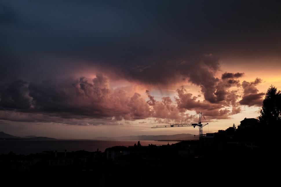 Free Image of Dramatic sky over a construction site at dusk 