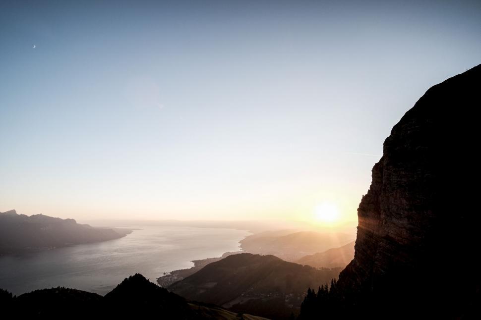 Free Image of Sunset over a coastal landscape from a peak 