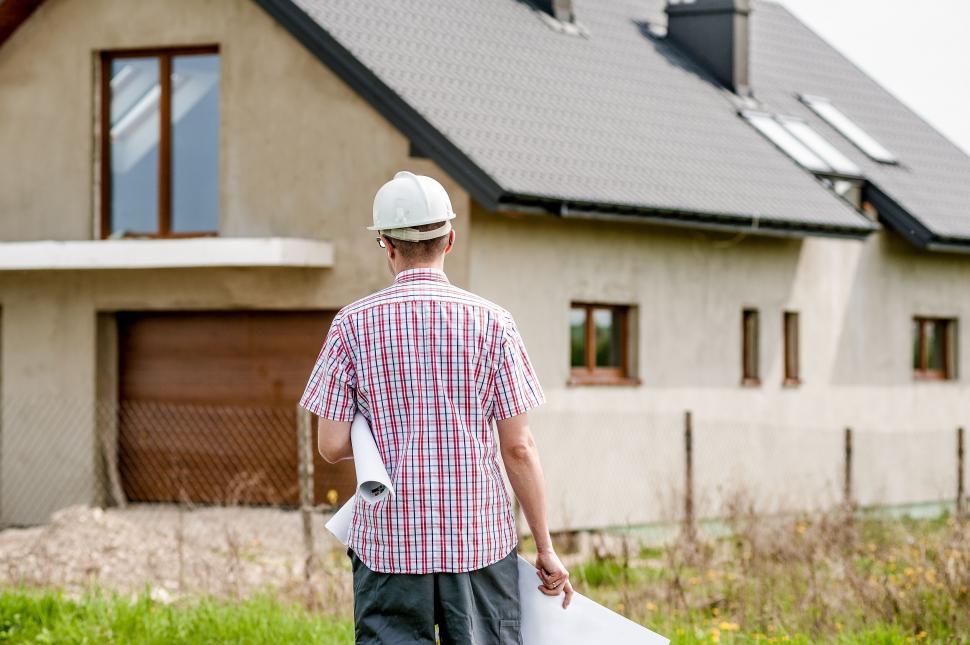 Free Image of Construction worker examining house exterior 