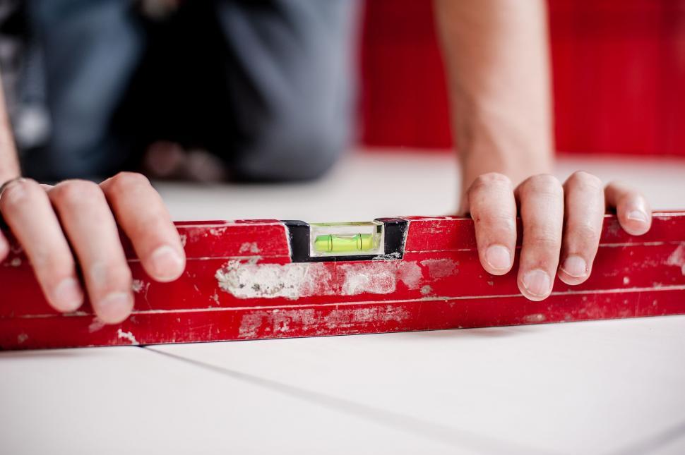 Free Image of Using a level on a white surface during construction 