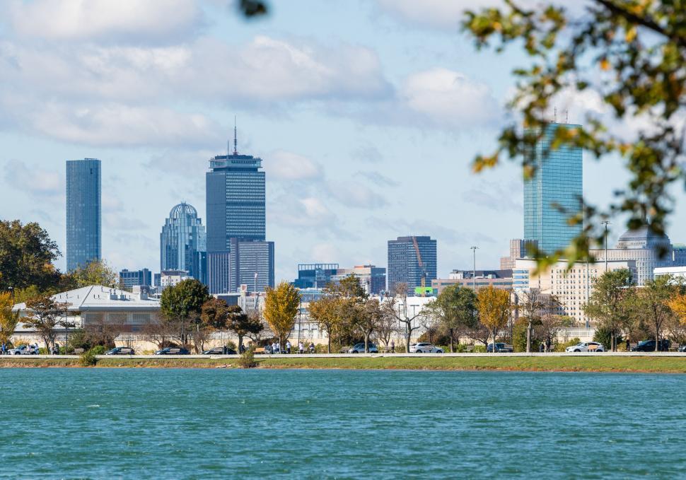 Free Image of Urban skyline over calm lake on sunny day 