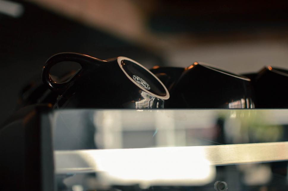 Free Image of Close-up of coffee cup handles on a shelf 