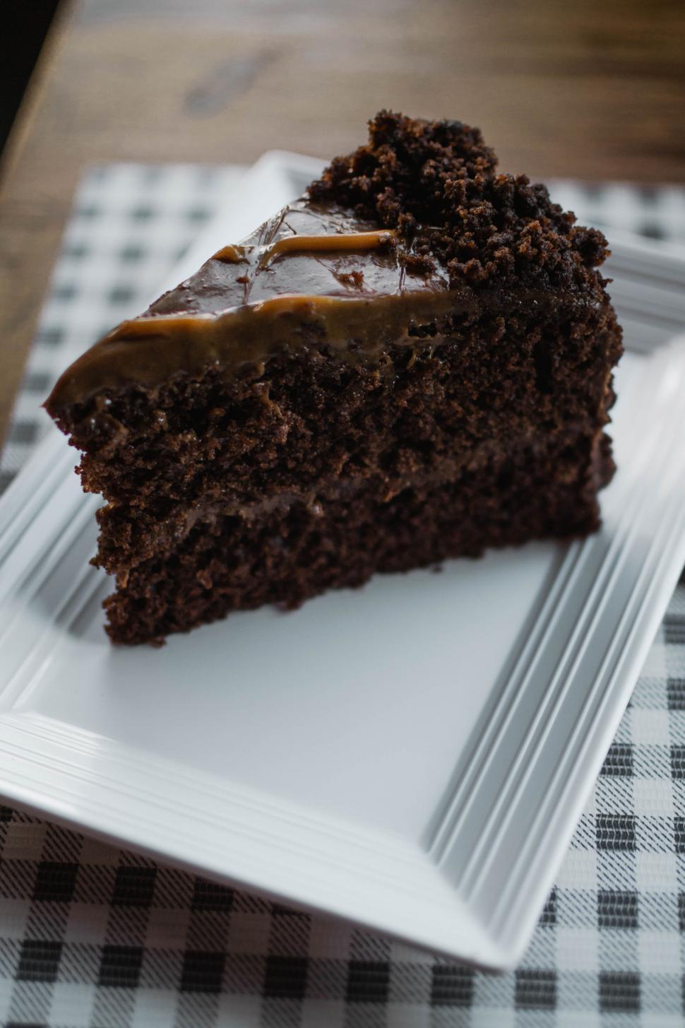 Free Image of Moist chocolate cake piece on checkered table 