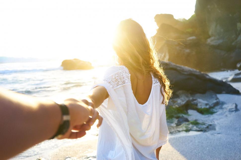 Free Image of Woman leading viewed from behind at beach 