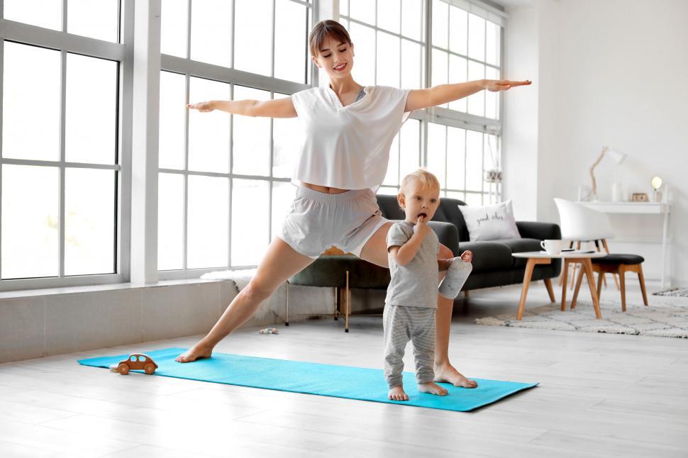 Free Image of Woman and toddler doing yoga pose in living room 