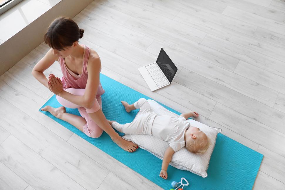 Free Image of Mother meditating next to her sleeping baby 