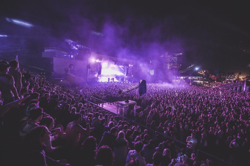 Vibrant concert crowd with raised hands enjoying live music performance