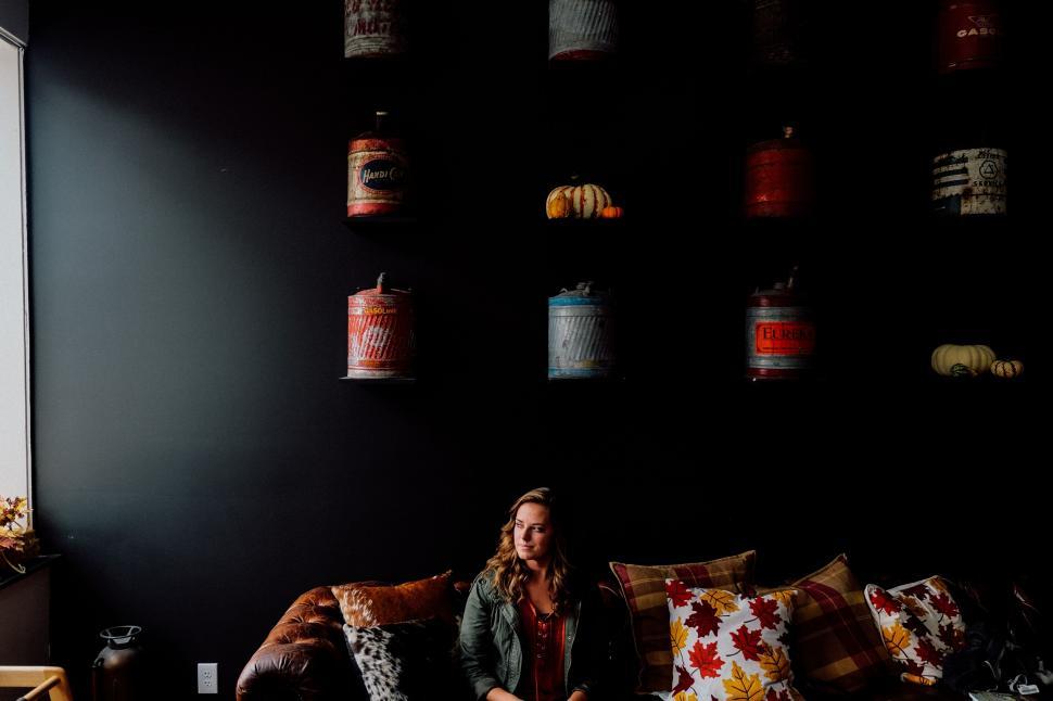 Free Image of Woman seated in cafe with antique lanterns 