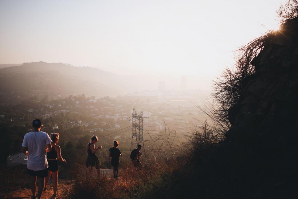 Free Image of Hikers enjoying sunset over cityscape 