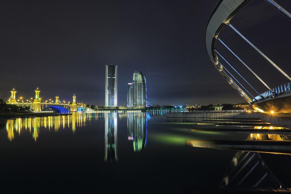 Free Image of Nighttime cityscape with illuminated bridge reflection 