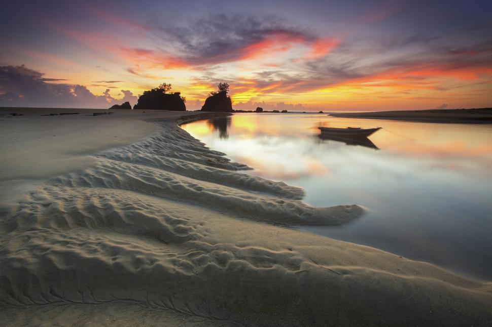 Free Image of Sandy beach with boat against sunset 
