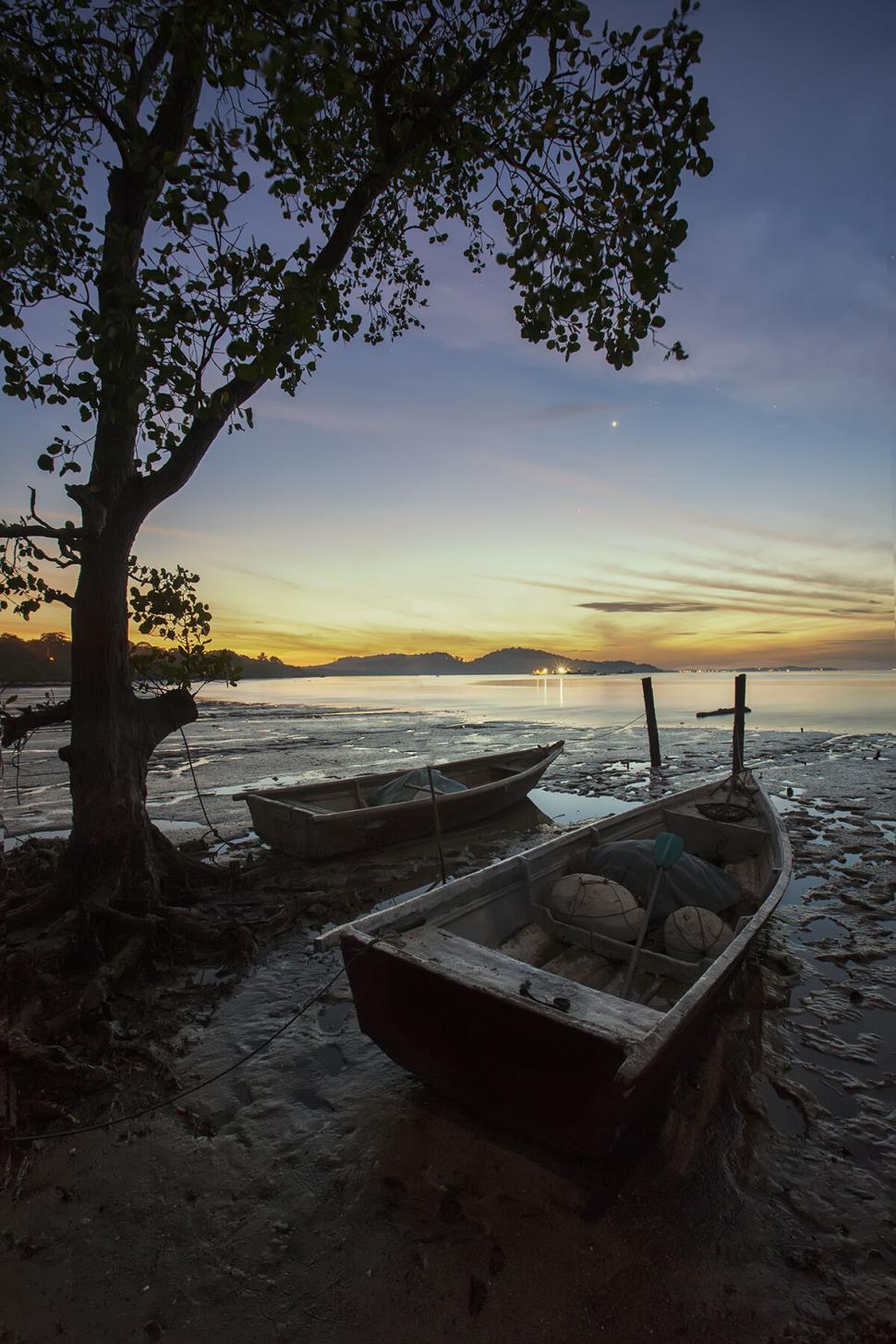 Free Image of Golden hour over peaceful shore with boats 