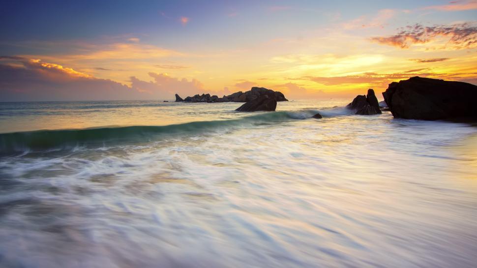 Free Image of Golden sunset with waves and rocky shore 