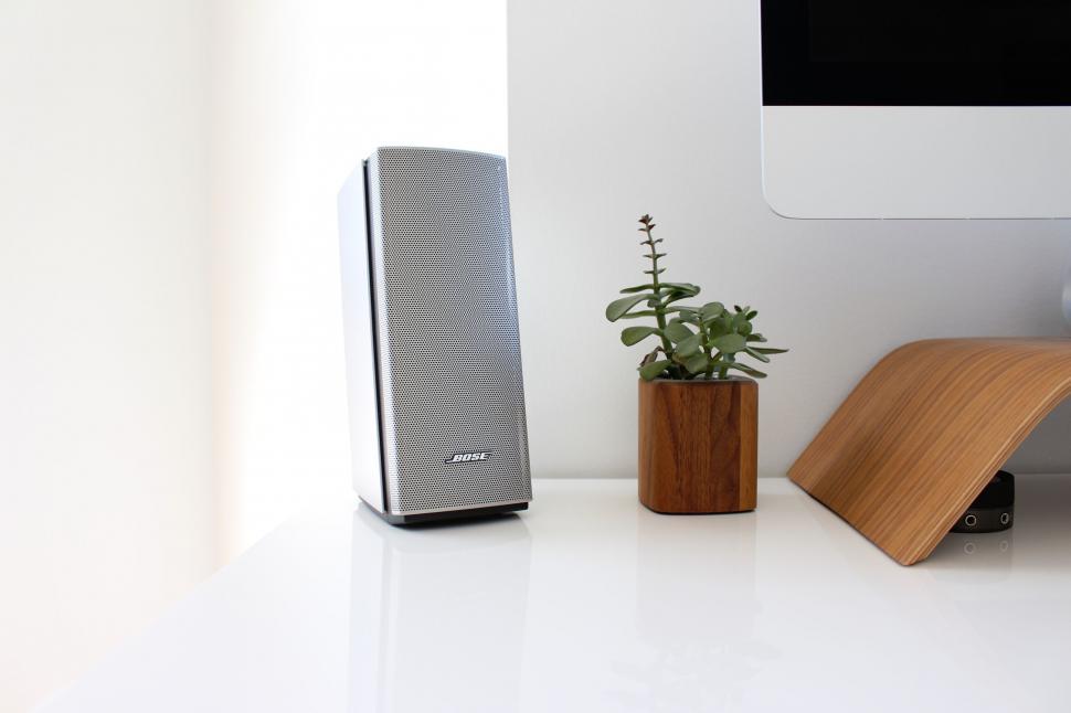 Free Image of Speaker next to iMac and plant 