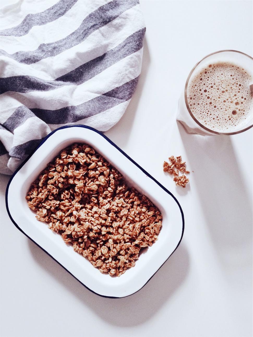 Free Image of Bowl of granola with milk near striped towel 