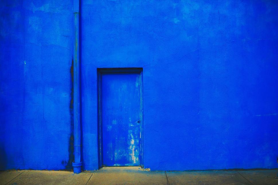Free Image of Vibrant blue wall with door and pipe 