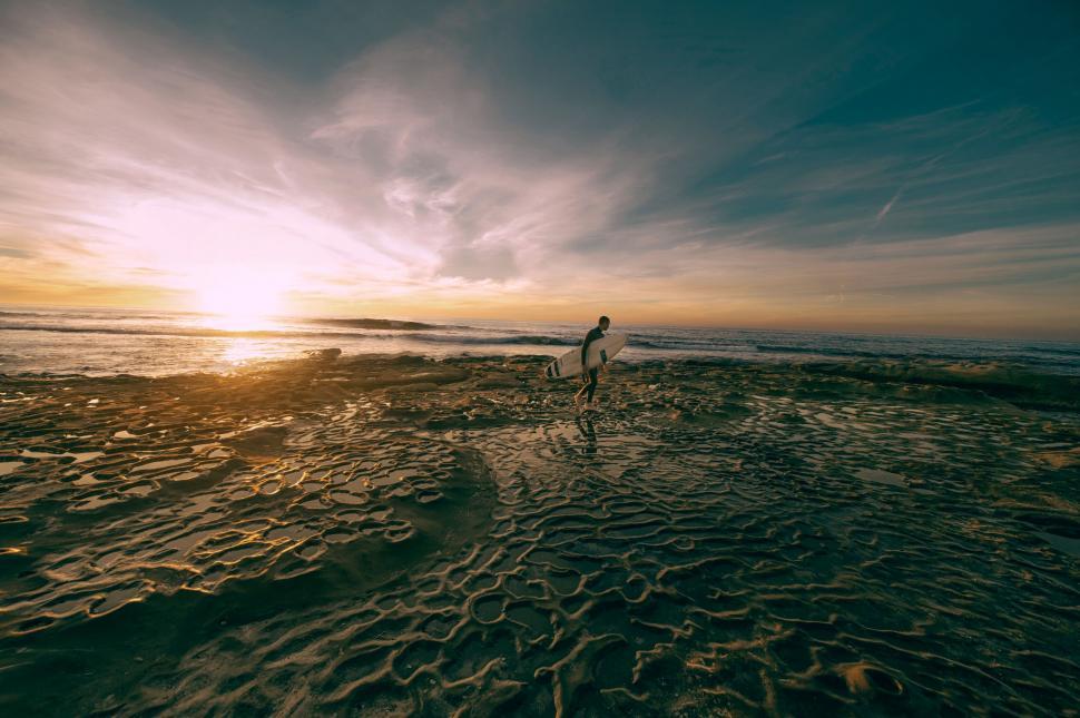 Free Image of Solitary figure on coastal tide pools at sunset 