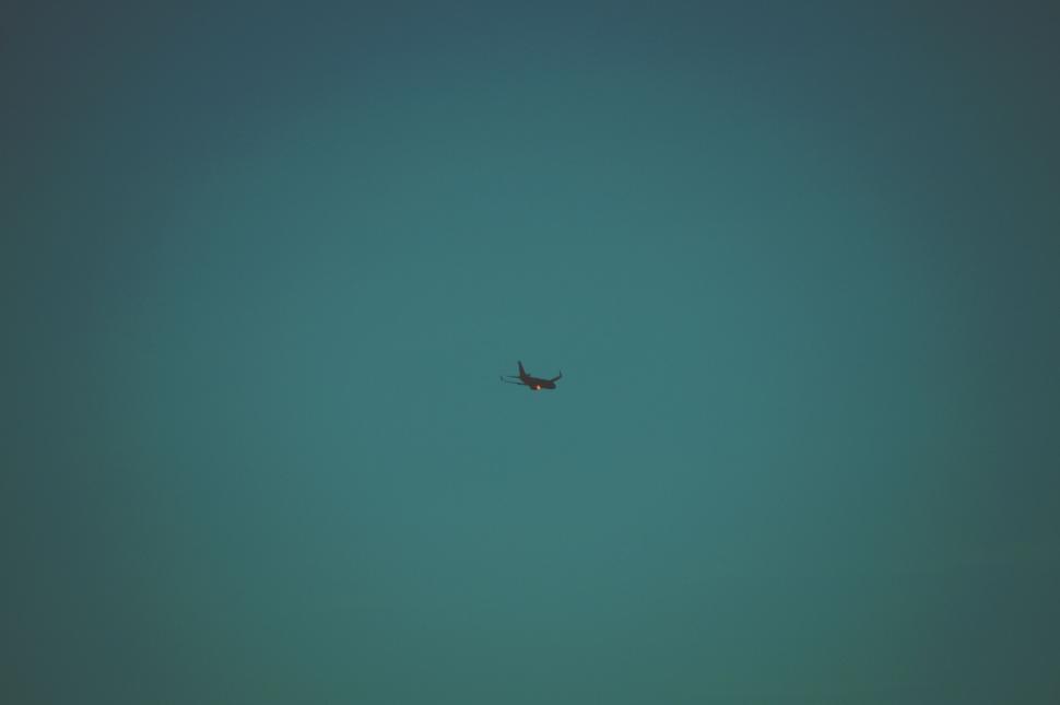 Free Image of Airplane silhouetted against blue sky 