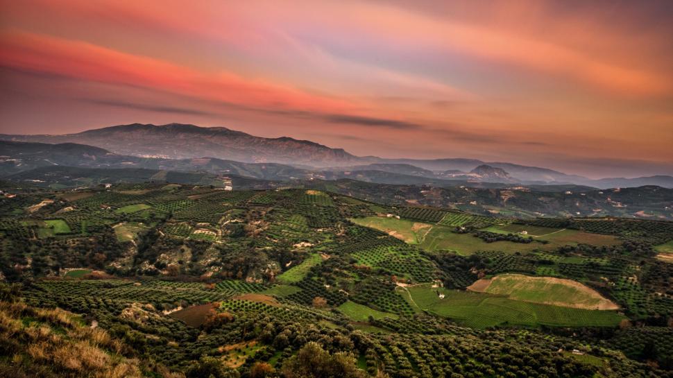 Free Image of Sunset casting warm hues over a hilly landscape 