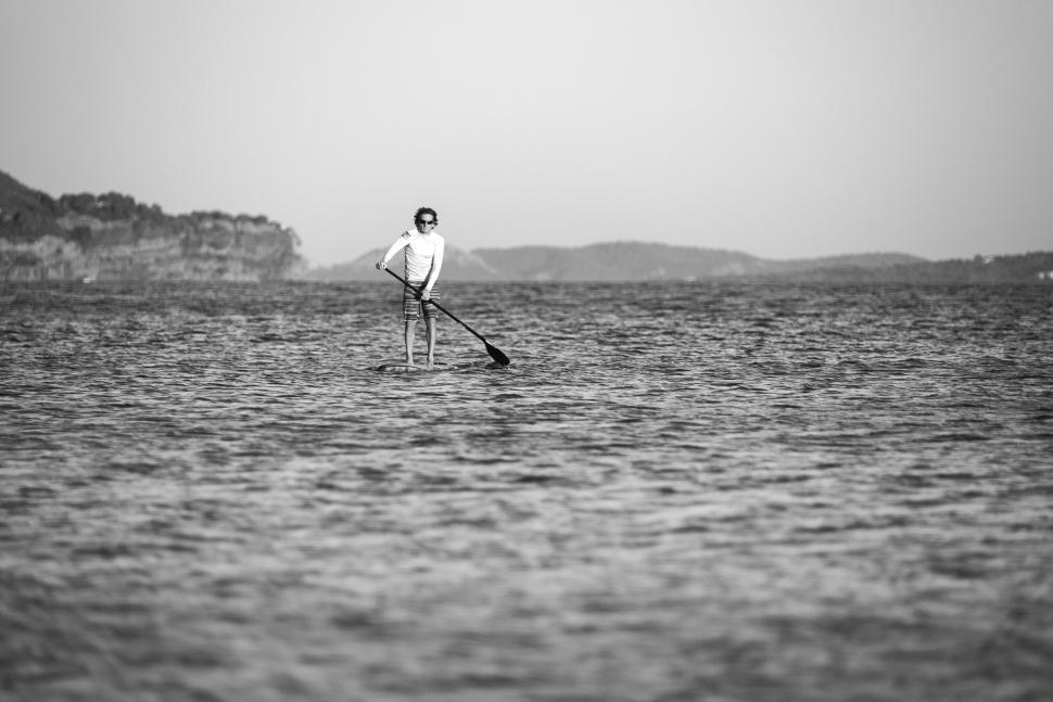 Free Image of Person paddle boarding in calm waters 
