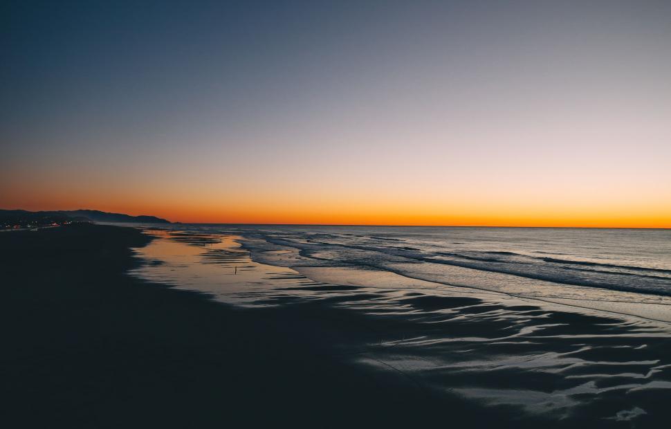Free Image of Serene beach sunset with mountains 