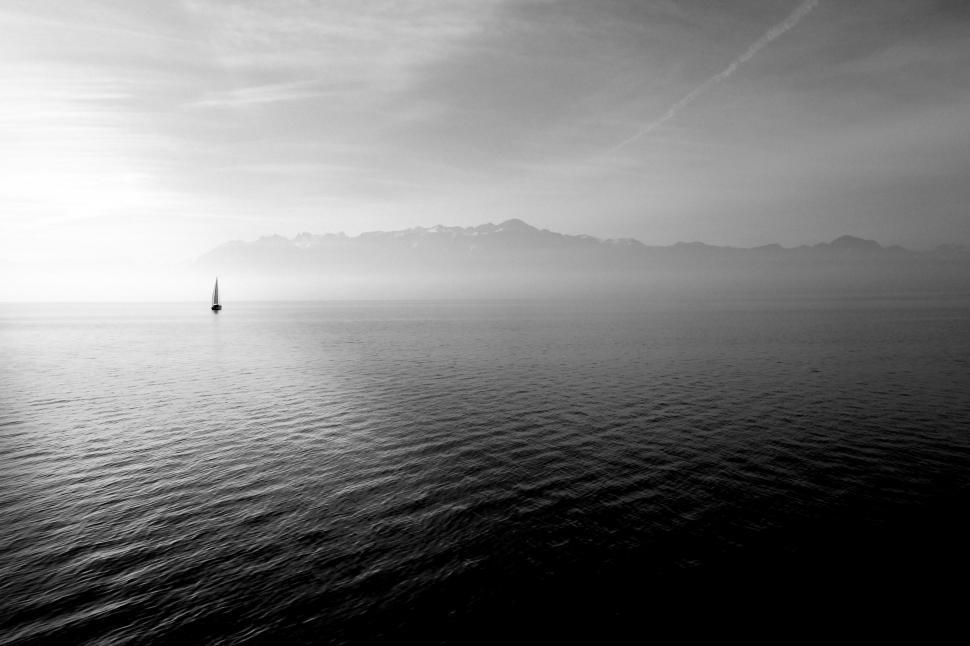 Free Image of Sailboat on misty lake with mountains 
