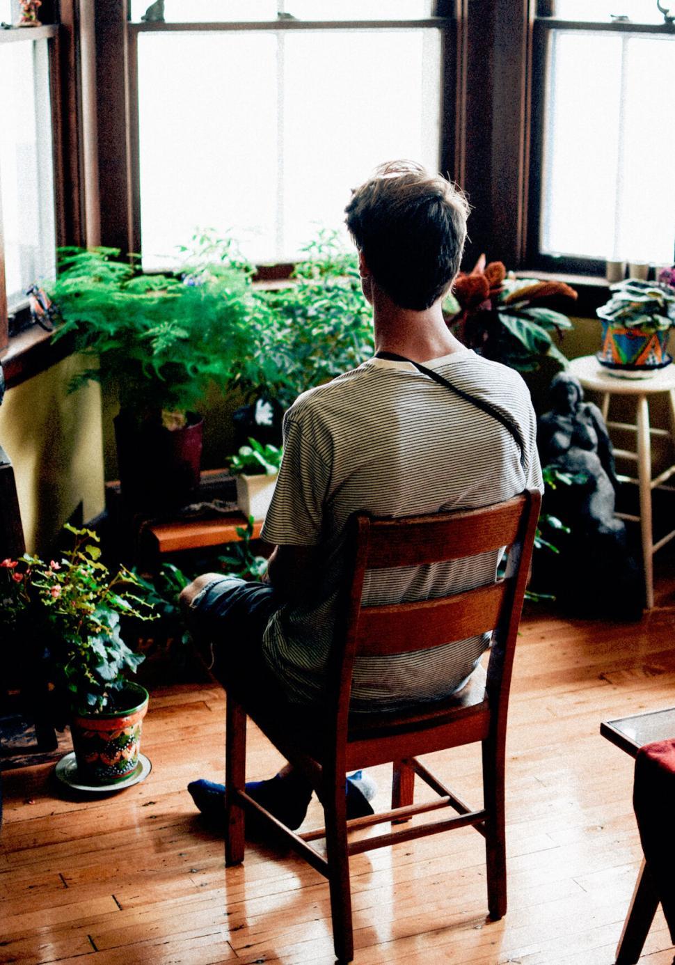 Free Image of Person Relaxed in Chair Surrounded by Houseplants 