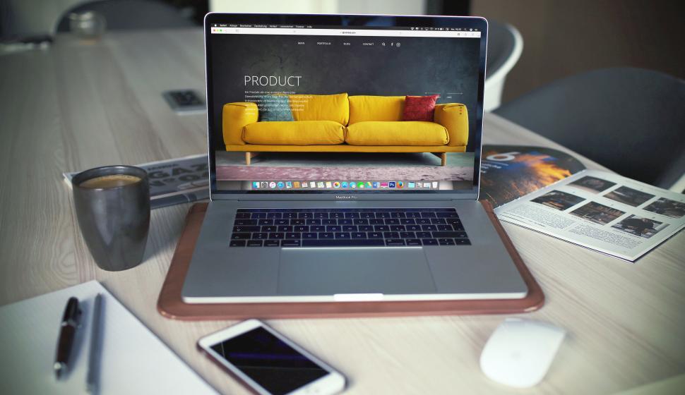 Free Image of Laptop on desk displaying furniture website 