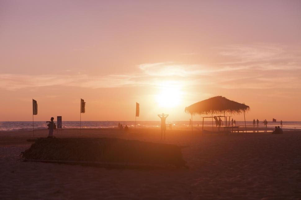 Free Image of Sunset at the beach with silhouettes 