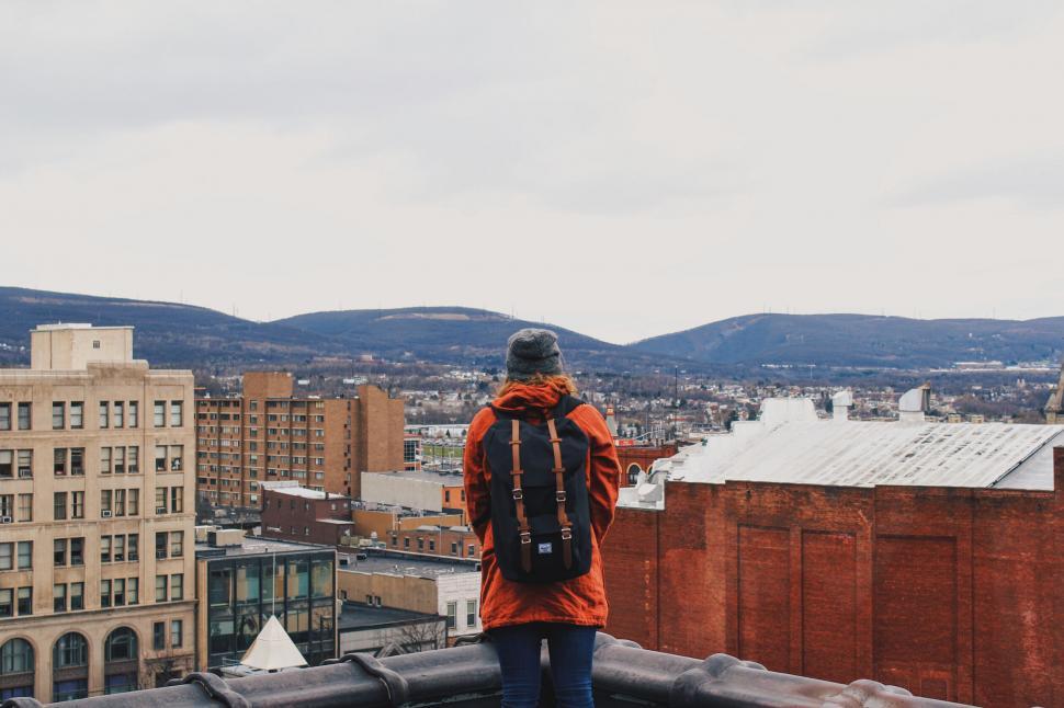 Free Image of Woman facing cityscape from a rooftop 