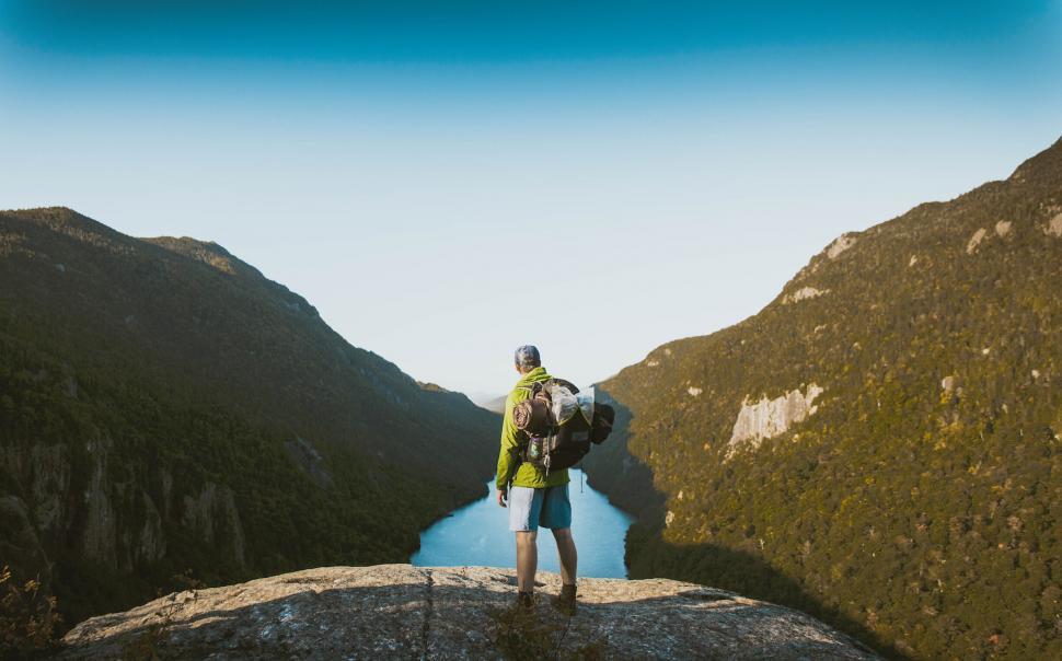 Free Image of Hiker observing a tranquil mountain valley 