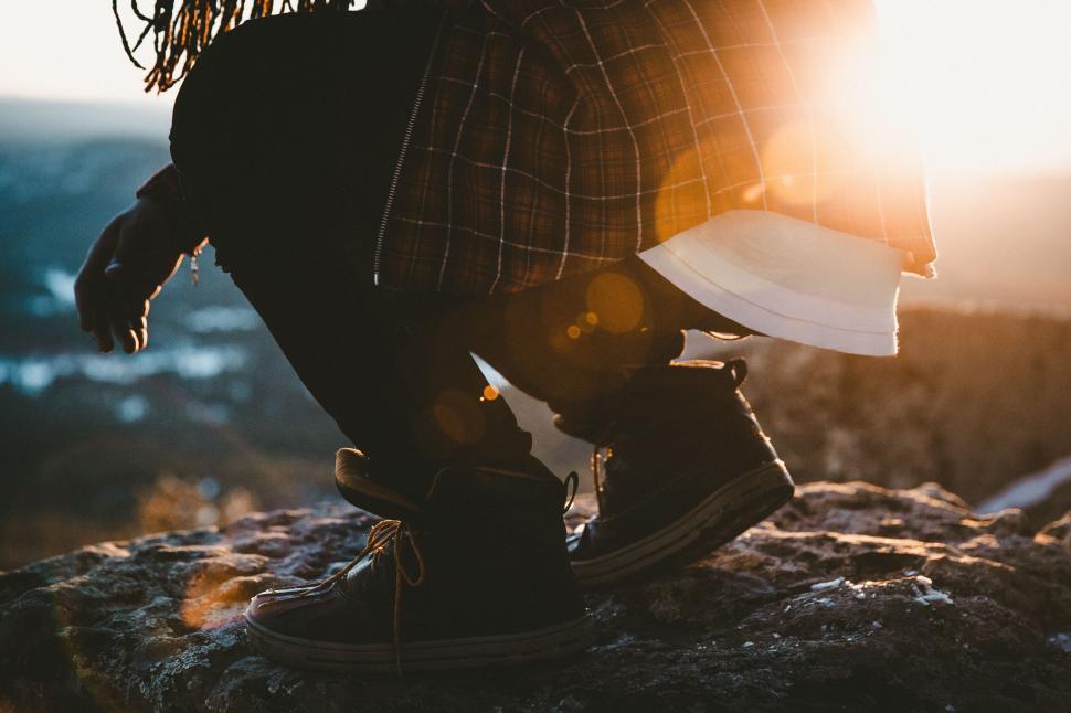 Free Image of Silhouette of person sitting on rock 