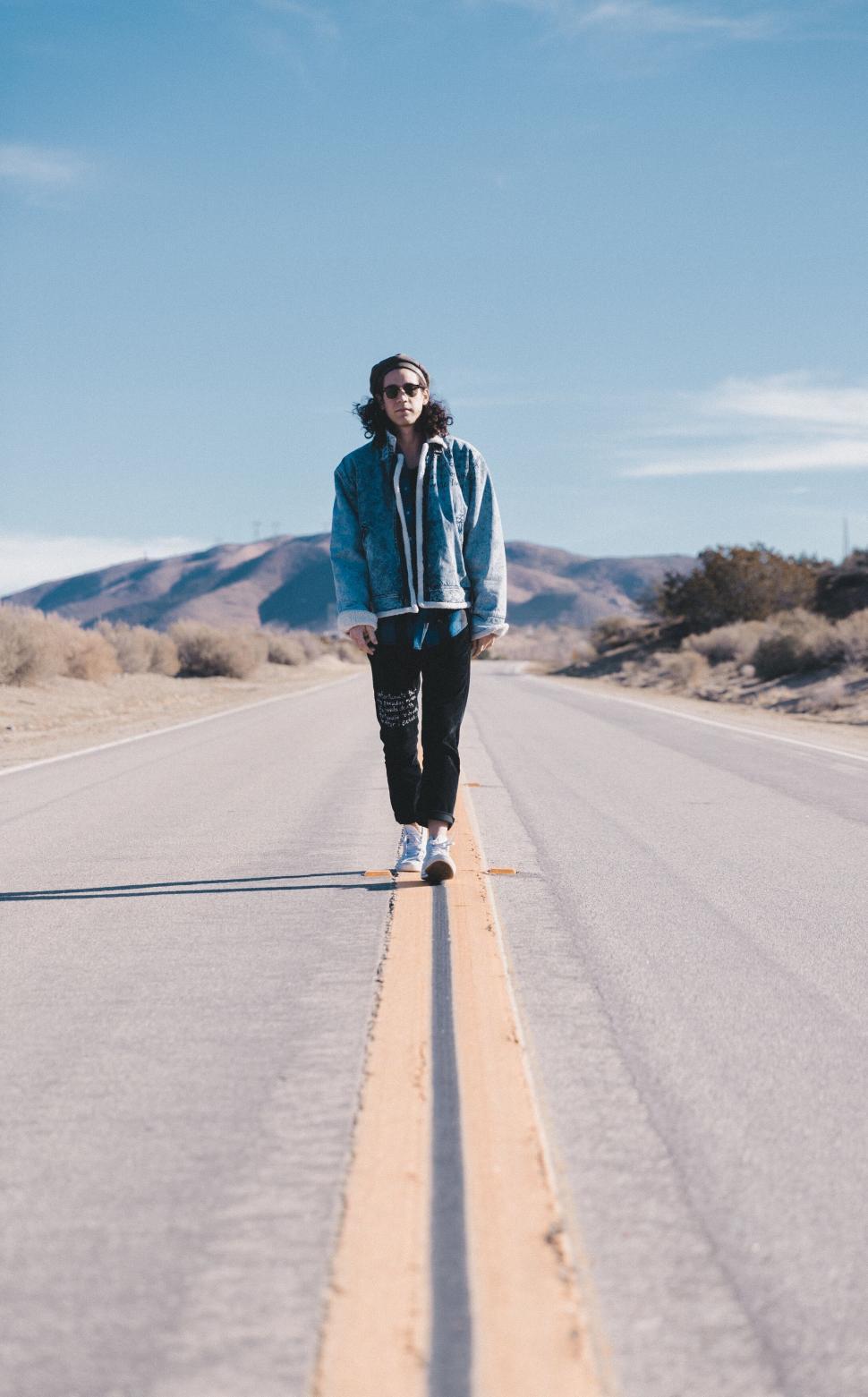 Free Image of Woman walking on an empty road 