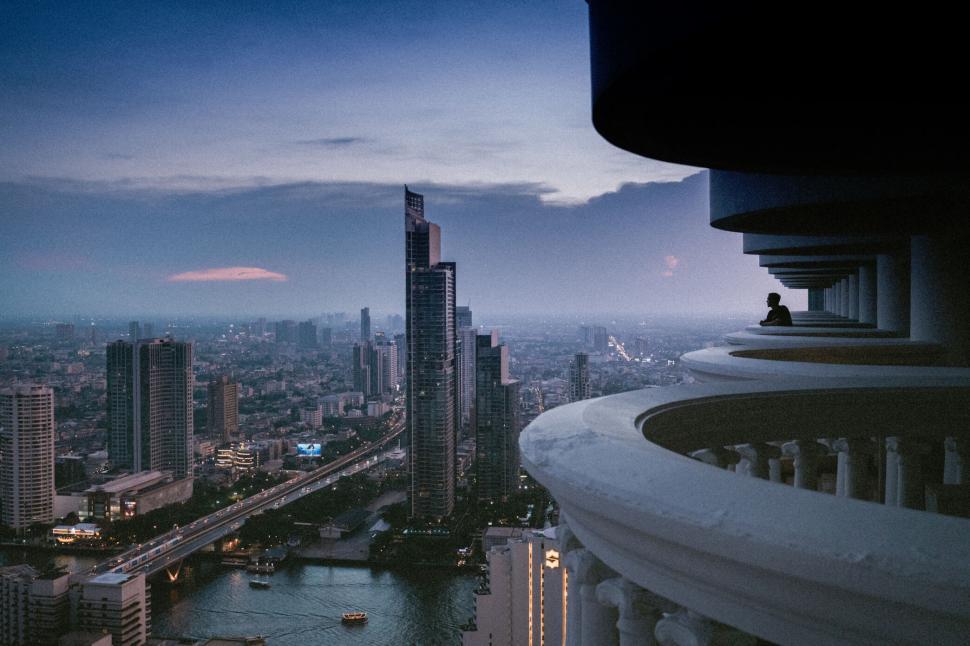 Free Image of Cityscape view with lone figure at twilight 