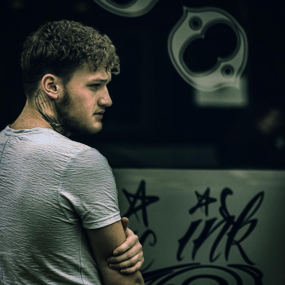 Free Image of Man leaning against urban art wall 