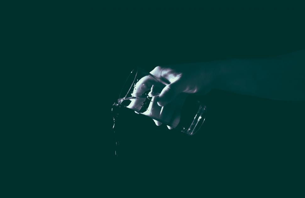 Free Image of Hand holding a glass of water in the dark 