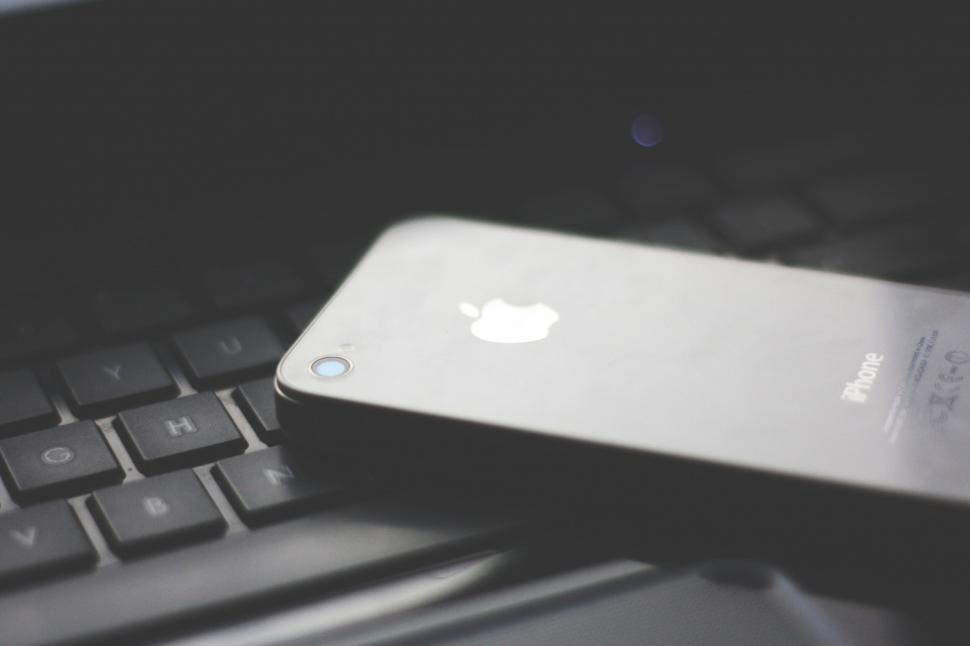 Free Image of Smartphone on laptop keyboard in low light 