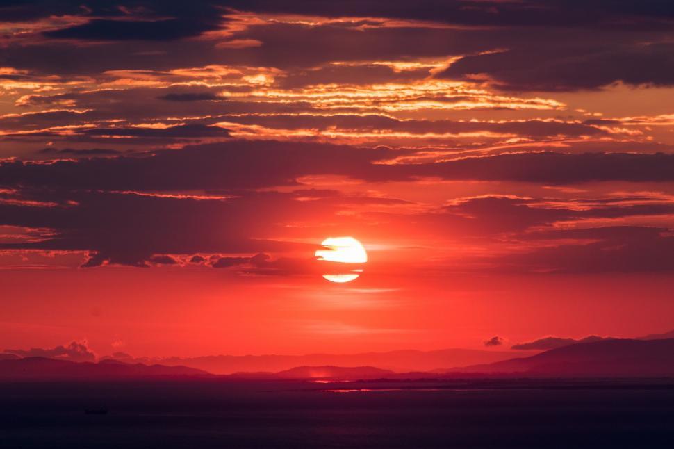 Free Image of Vivid sunset with dramatic clouds over the ocean 