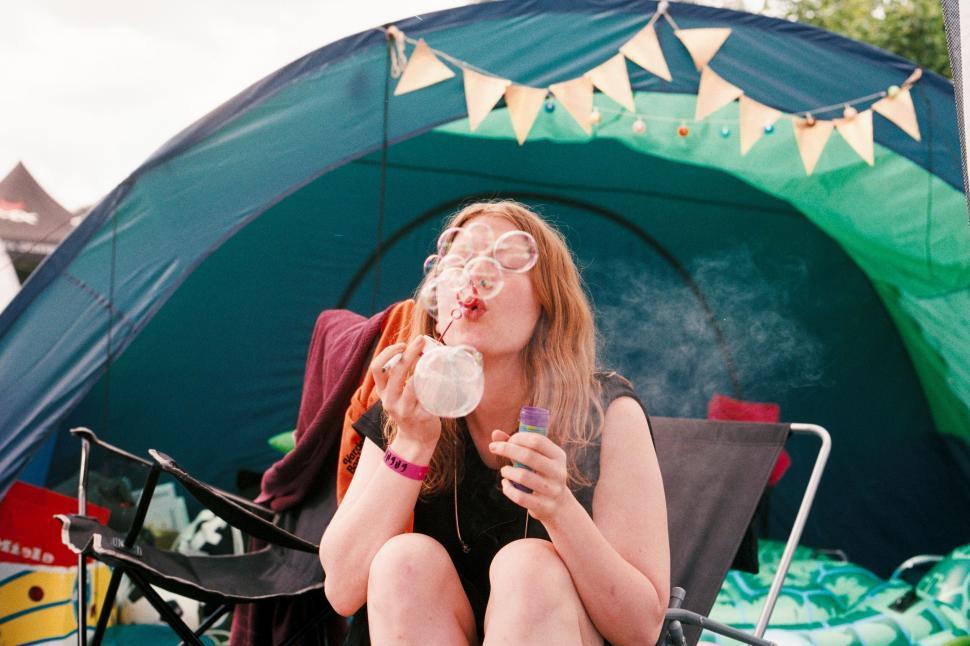 Free Image of Festival-goer blowing bubbles at campsite 