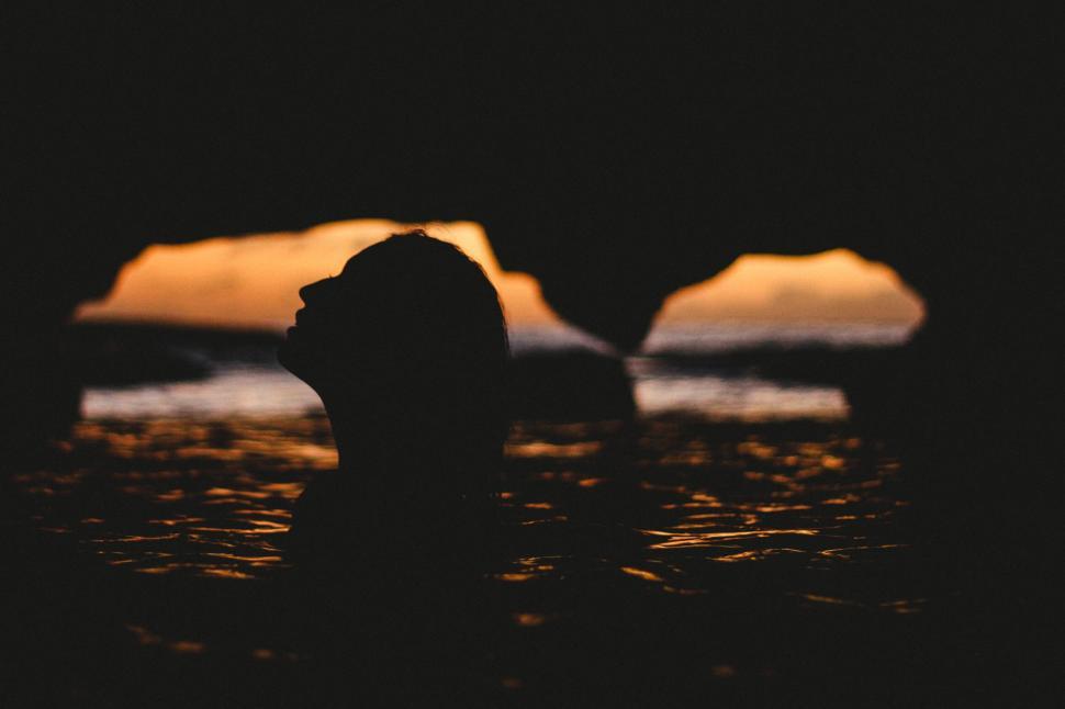 Free Image of Silhouette of a person against sunset sea 