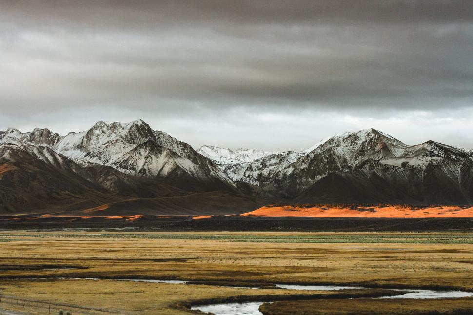 Free Image of Snowy mountain peaks with orange sand dunes 