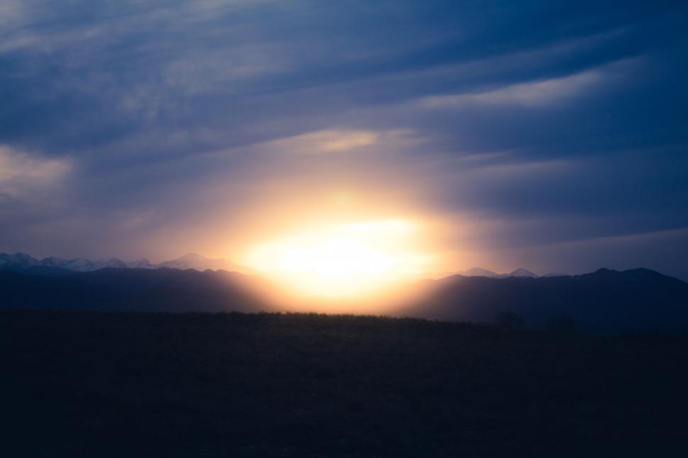 Free Image of Sunrise over mountain range with blue sky 