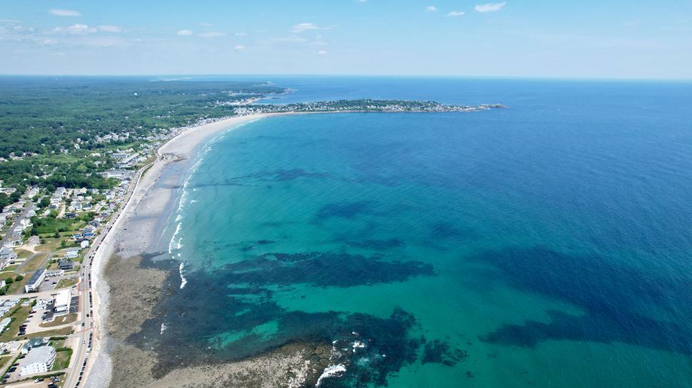 Free Image of Coastal town with clear blue sea and beach 