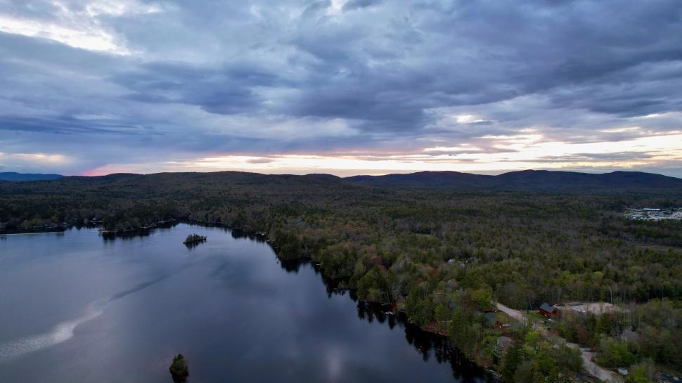 Free Image of Serene lakeside landscape under dramatic dusk skies. 