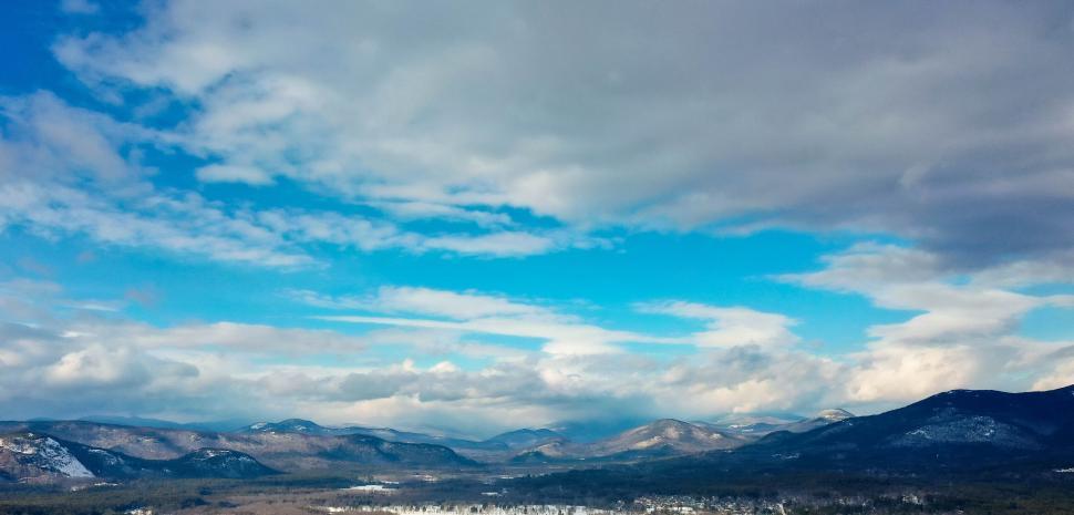 Free Image of Panoramic view of mountain range under a blue sky. 