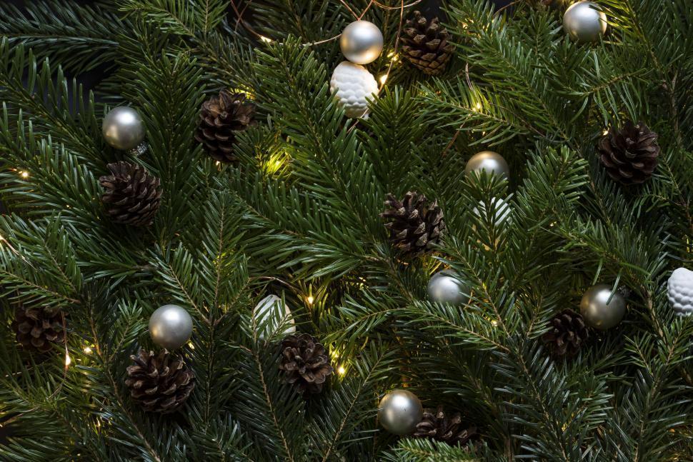 Free Image of Christmas tree with pinecones and ornaments lit up 