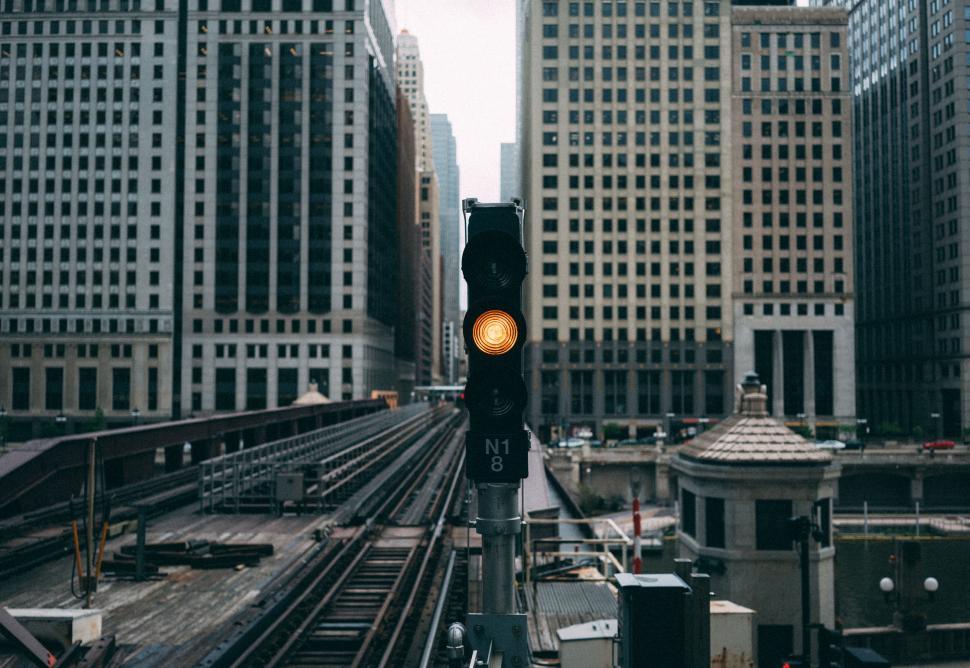 Free Image of Urban train tracks with orange signal light in city 