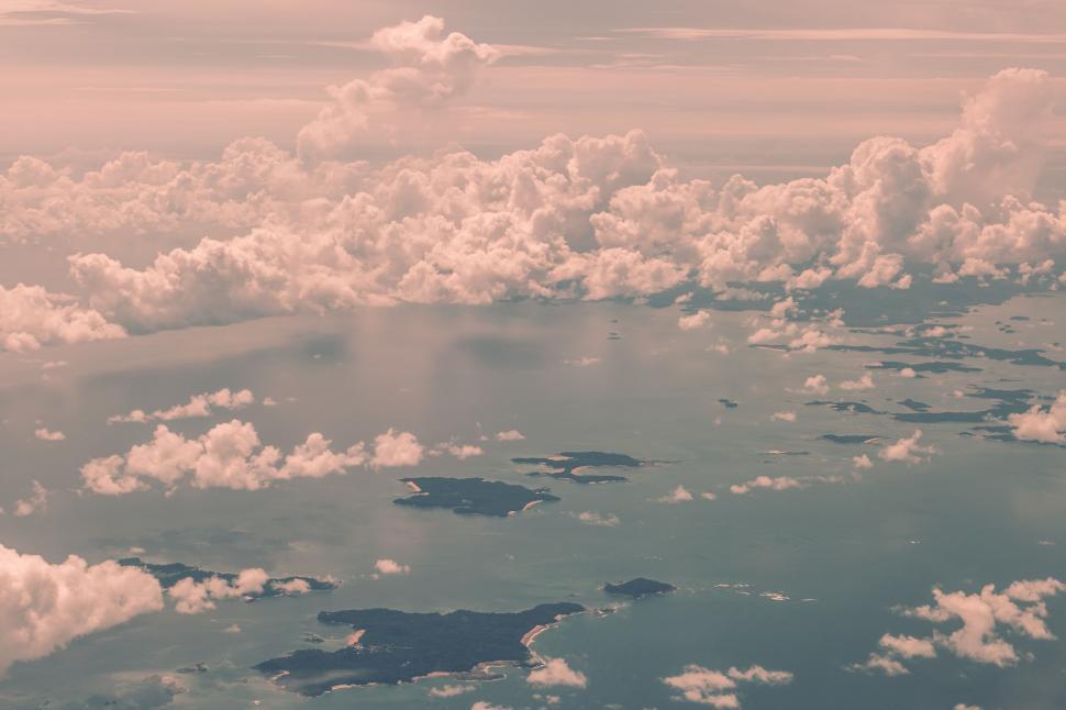 Free Image of Aerial view of islands and clouds during a pink sunset 