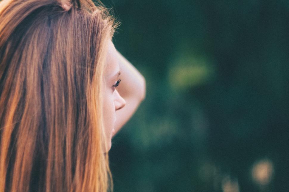 Free Image of Woman with long hair in an outdoor setting side view 